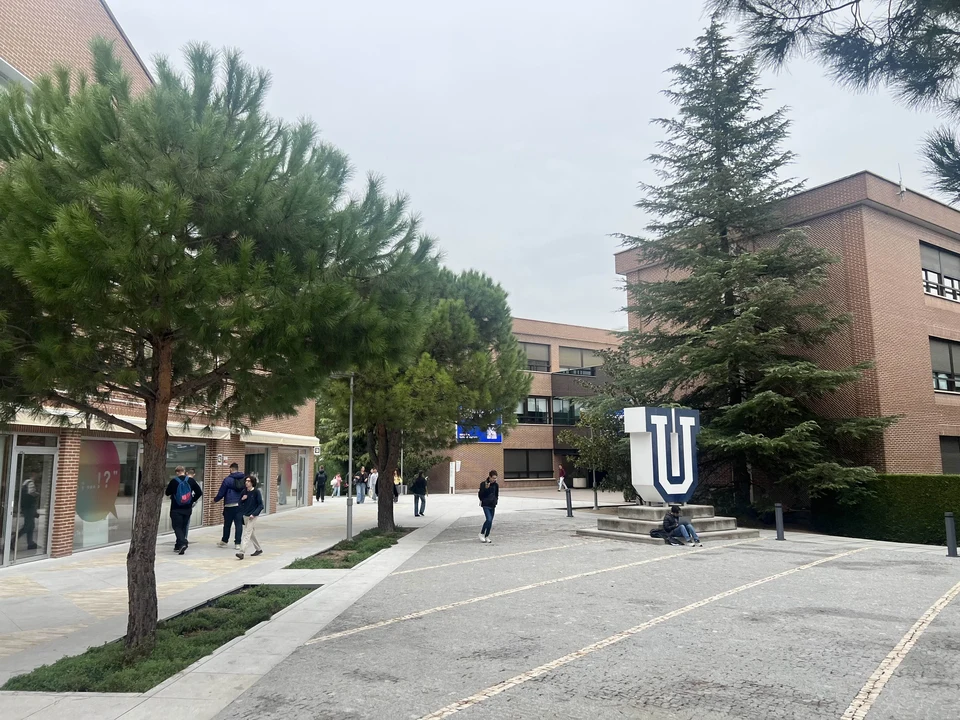 The UFV campus in Madrid, with brick university buildings, trees and a large U symbol in the square.